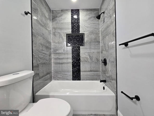 bathroom featuring toilet and tiled shower / bath