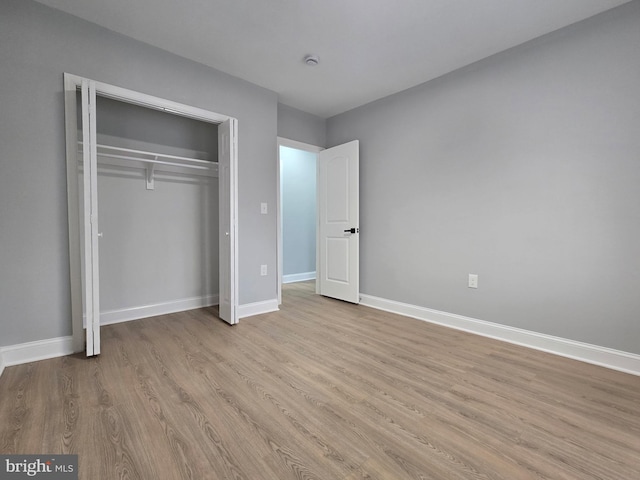 unfurnished bedroom with light hardwood / wood-style floors and a closet