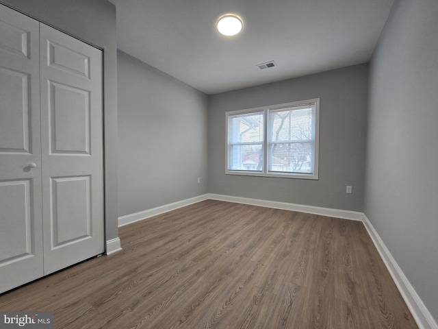 unfurnished bedroom with light hardwood / wood-style flooring and a closet