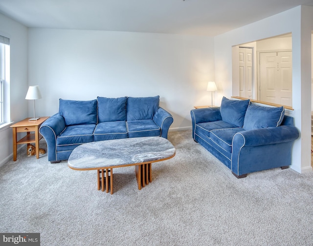 carpeted living area with baseboards