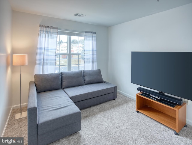 living room with carpet flooring, visible vents, and baseboards