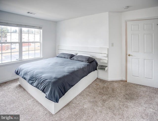 bedroom featuring light carpet, visible vents, and baseboards