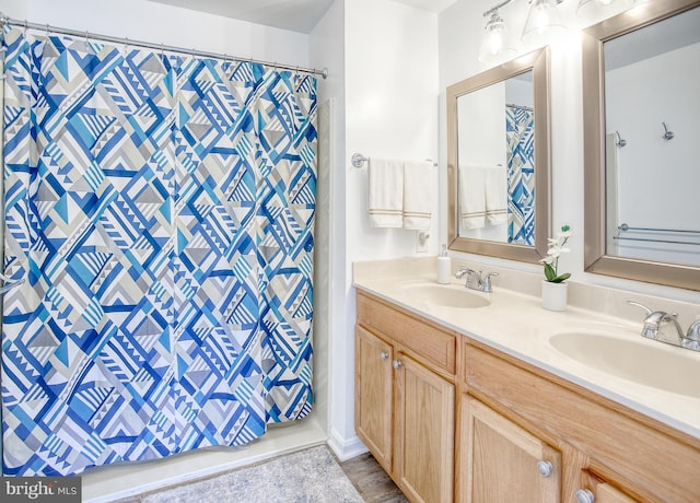 full bath with double vanity, curtained shower, and a sink