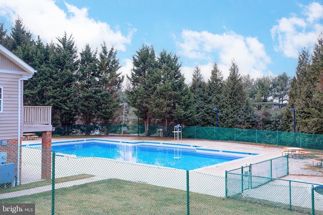 community pool featuring fence and a lawn