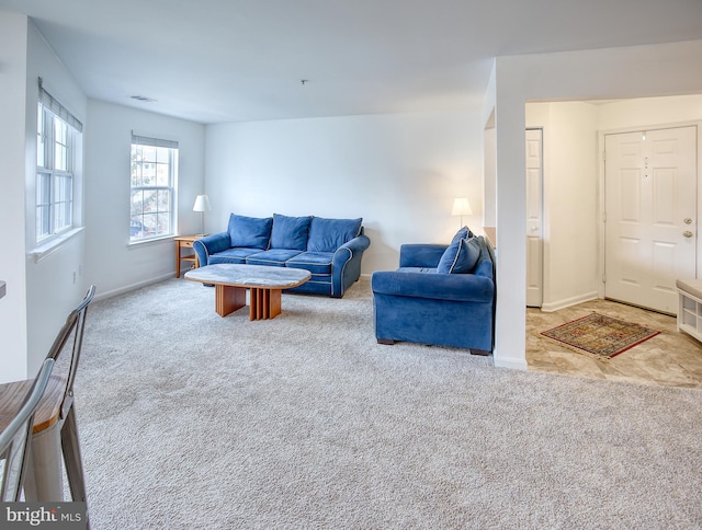 living room with light carpet, visible vents, and baseboards