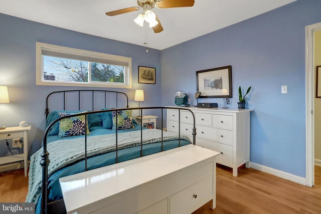 bedroom featuring ceiling fan, light wood finished floors, and baseboards