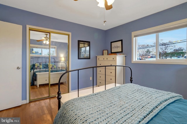 bedroom featuring baseboards, a closet, a ceiling fan, and wood finished floors