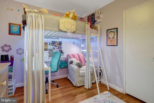 bedroom with baseboards and wood finished floors