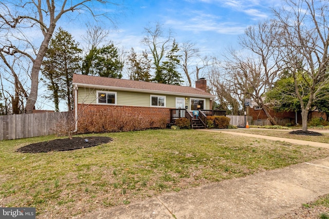 ranch-style house featuring brick siding, fence, a chimney, and a front lawn