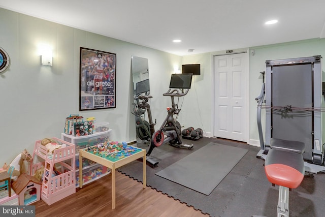 workout area featuring baseboards, wood finished floors, and recessed lighting