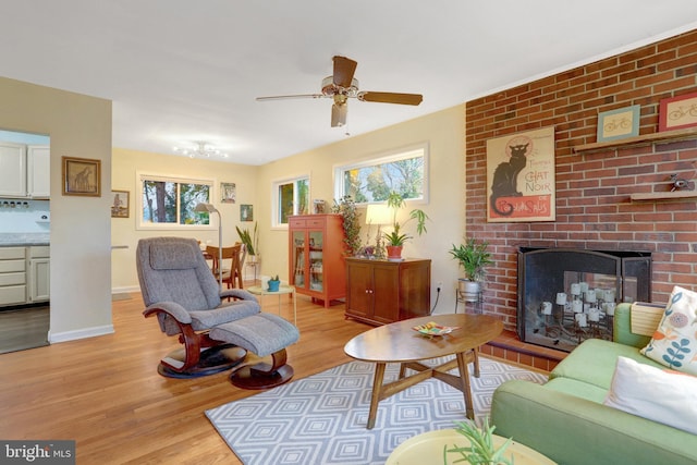 living area with a healthy amount of sunlight, light wood finished floors, a fireplace, and baseboards