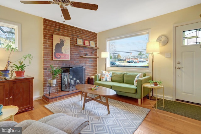 living area with a fireplace, wood finished floors, and baseboards