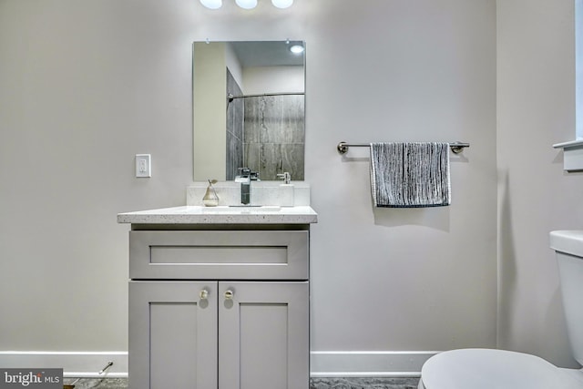 bathroom featuring vanity, toilet, and a shower with shower door