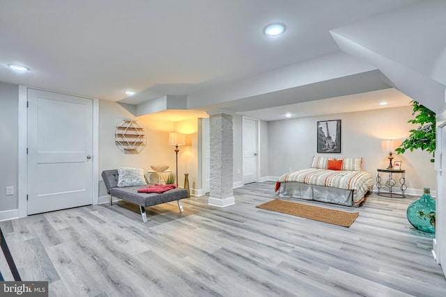 bedroom featuring ornate columns and light hardwood / wood-style flooring