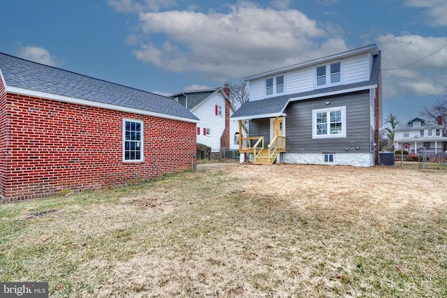 rear view of property featuring a yard