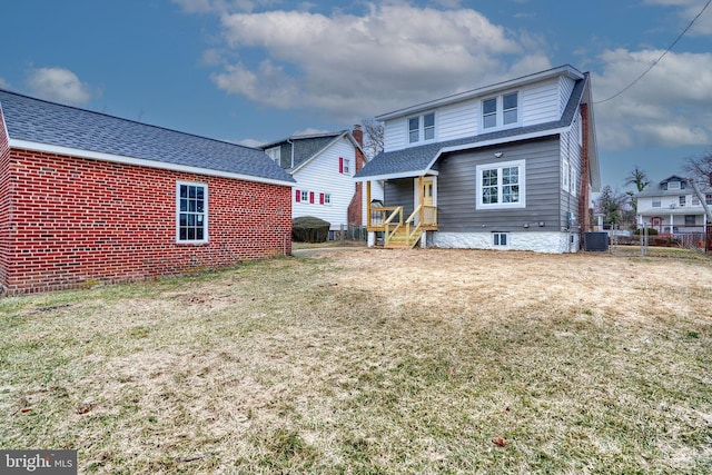 rear view of house with a yard and central air condition unit