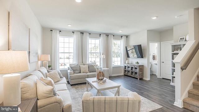 living room featuring dark wood-type flooring and plenty of natural light