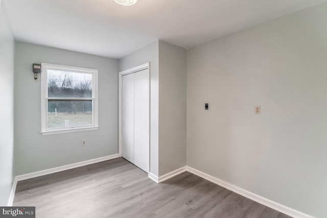 unfurnished bedroom featuring wood-type flooring and a closet