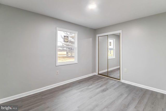 unfurnished bedroom featuring light hardwood / wood-style flooring and a closet