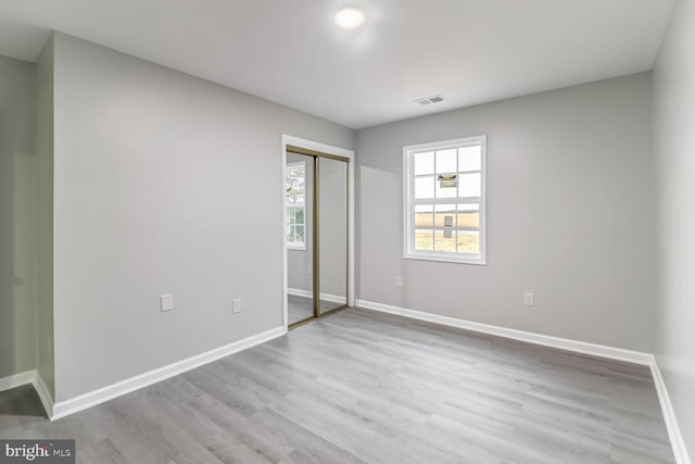 unfurnished bedroom featuring a closet and light hardwood / wood-style flooring