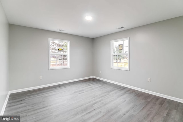 unfurnished room featuring hardwood / wood-style flooring and a healthy amount of sunlight