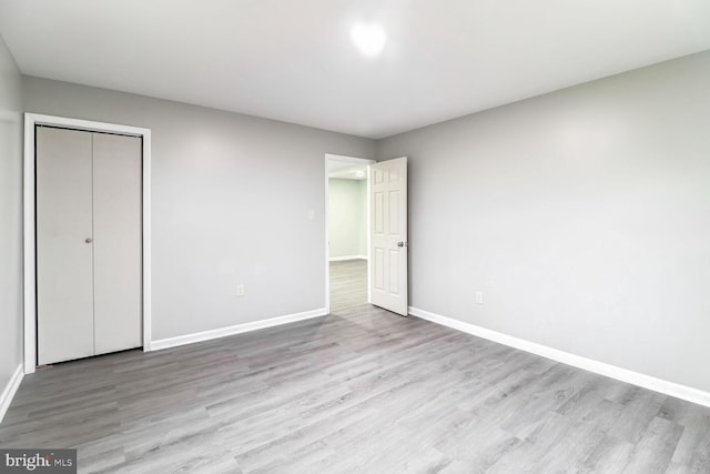 unfurnished bedroom with light hardwood / wood-style floors and a closet