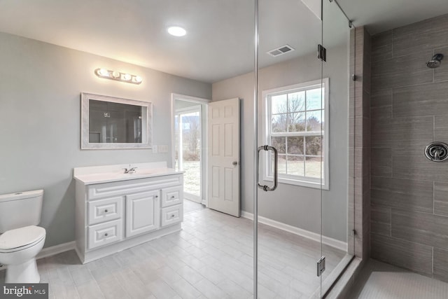 bathroom featuring walk in shower, vanity, and toilet