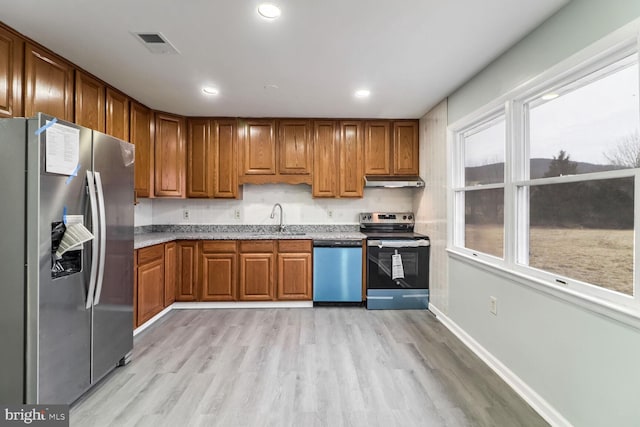 kitchen featuring appliances with stainless steel finishes, sink, and light hardwood / wood-style flooring