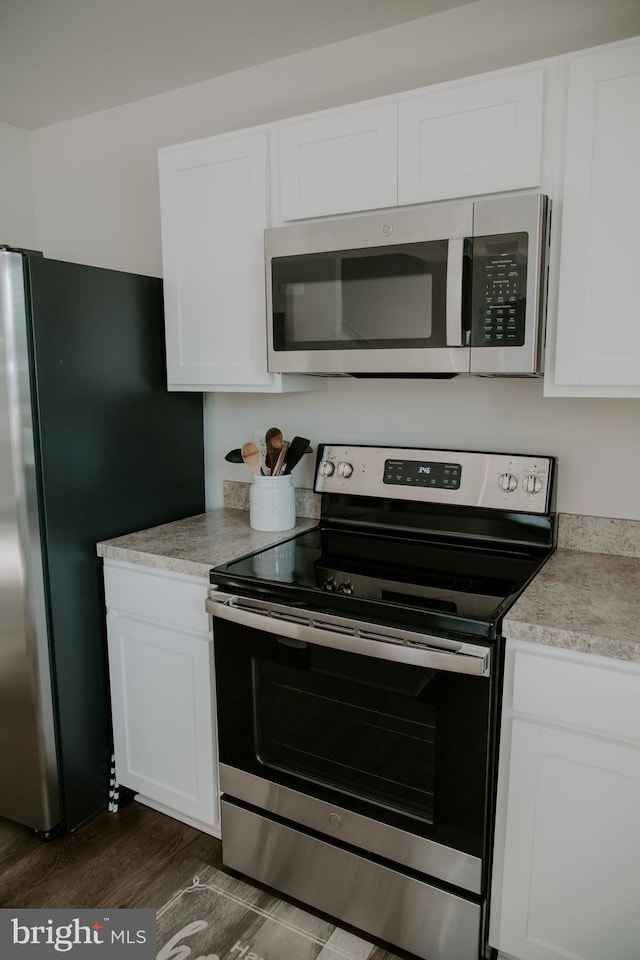 kitchen featuring white cabinetry, dark wood-type flooring, and stainless steel appliances