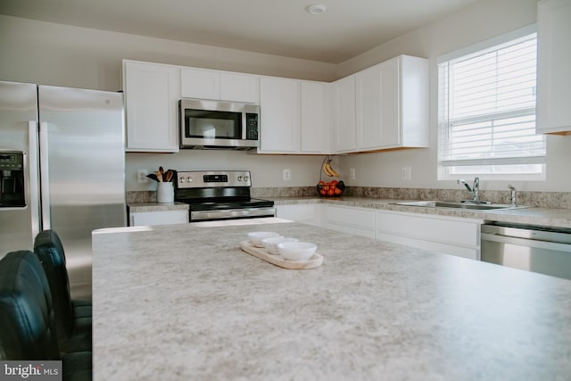 kitchen featuring stainless steel appliances, sink, and white cabinets