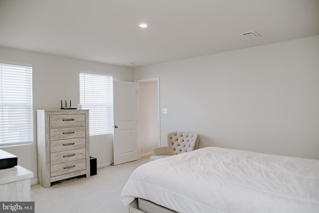 bedroom with multiple windows and light colored carpet