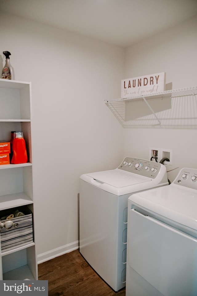 laundry room featuring washing machine and clothes dryer and dark hardwood / wood-style flooring