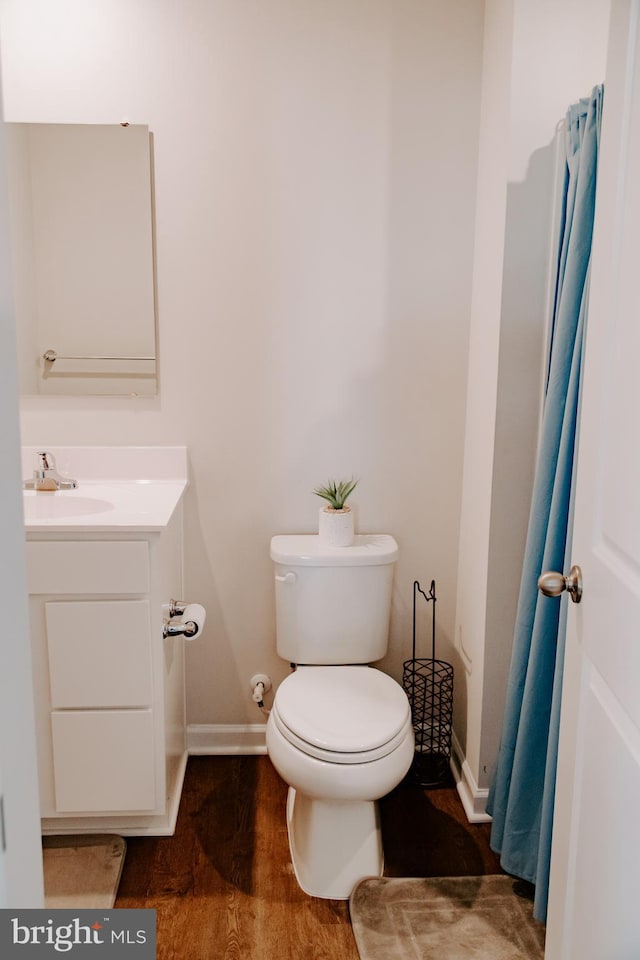 bathroom featuring wood-type flooring, vanity, and toilet