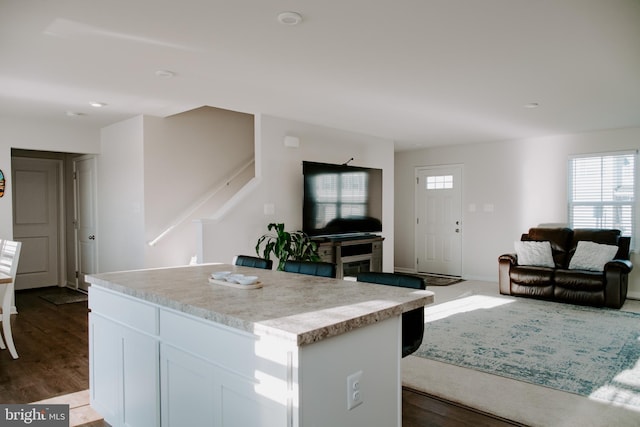 kitchen with dark hardwood / wood-style flooring, a center island, and white cabinets