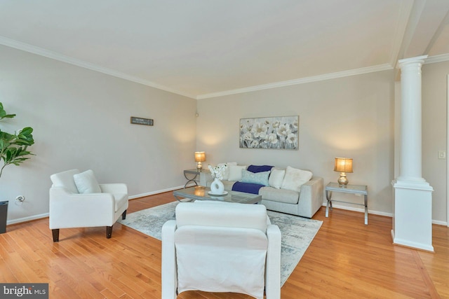 living room with crown molding, baseboards, light wood-style floors, and ornate columns