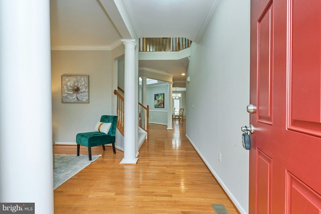 foyer featuring stairway, visible vents, ornate columns, ornamental molding, and light wood-style floors