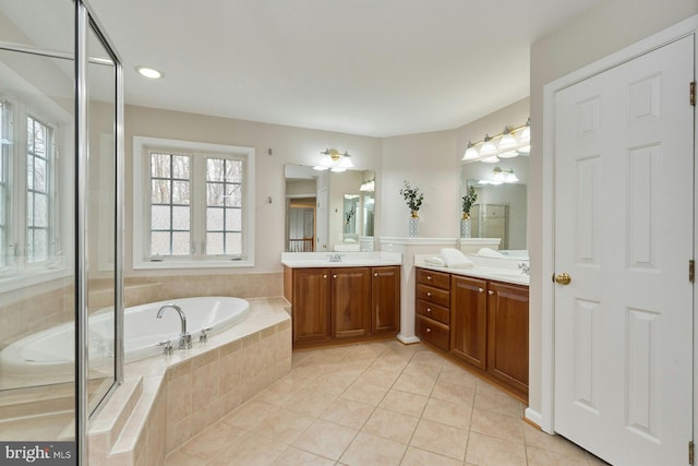 full bath featuring a shower with shower door, two vanities, a sink, tile patterned flooring, and a garden tub