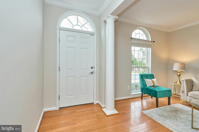 foyer with light wood-style flooring, baseboards, crown molding, and ornate columns