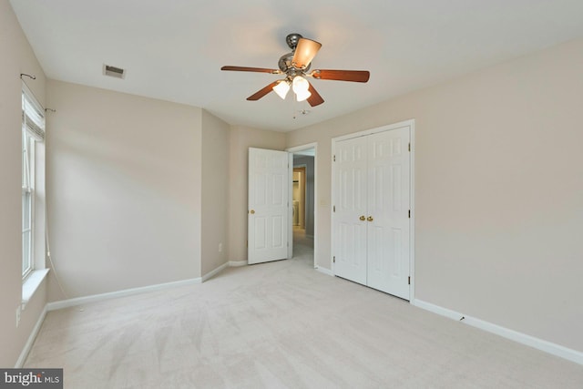 unfurnished bedroom with baseboards, visible vents, and light carpet