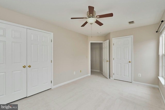 unfurnished bedroom featuring visible vents, baseboards, light carpet, and ceiling fan