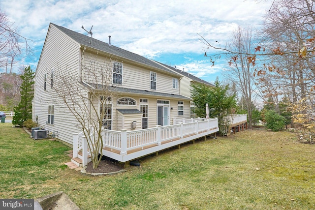 back of property with a deck, cooling unit, and a yard