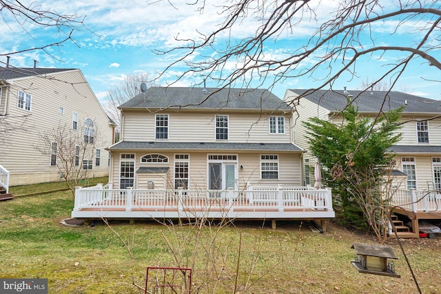 rear view of house with a lawn and a wooden deck