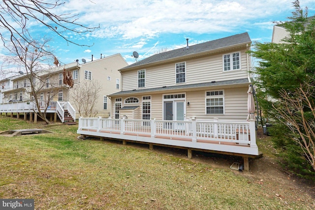 rear view of property with a lawn and a deck