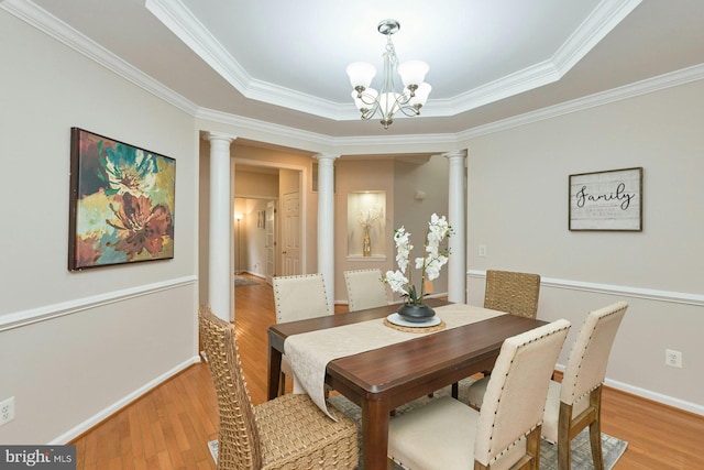 dining area with crown molding, baseboards, decorative columns, an inviting chandelier, and light wood-style floors