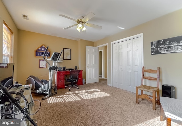 carpeted office featuring ceiling fan