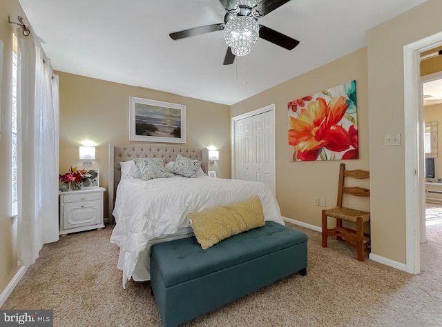 carpeted bedroom with multiple windows, ceiling fan, and a closet