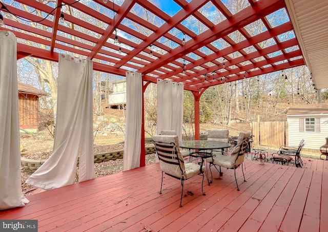 wooden deck with a storage shed and a pergola