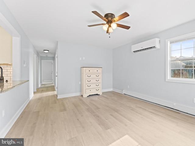 unfurnished room featuring ceiling fan, light hardwood / wood-style floors, a wall unit AC, and a baseboard heating unit