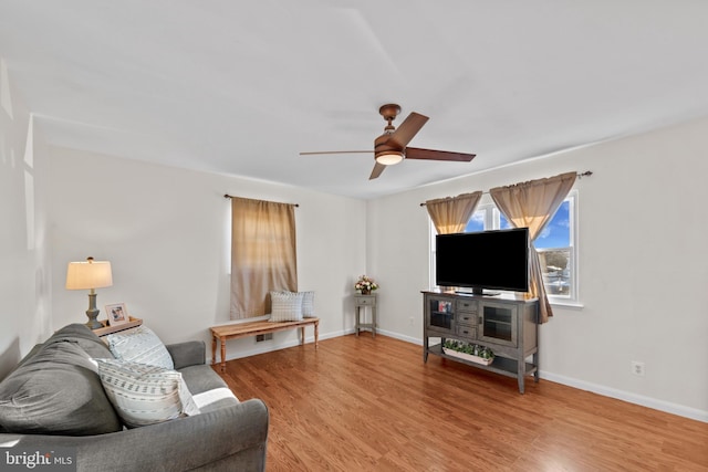 living room featuring hardwood / wood-style floors and ceiling fan