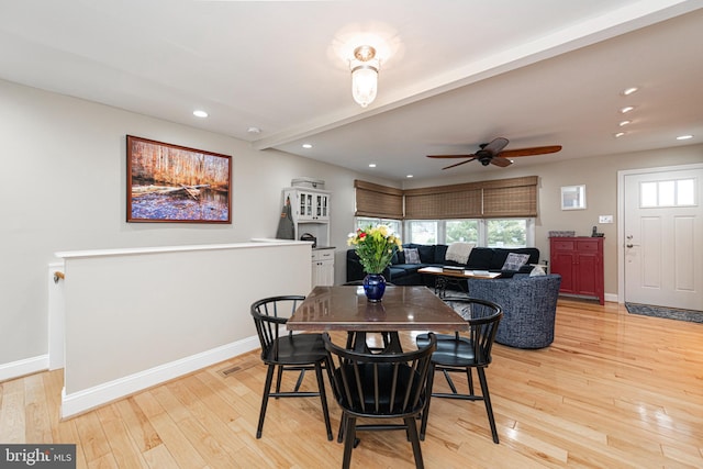 dining area featuring ceiling fan, light hardwood / wood-style flooring, and beamed ceiling